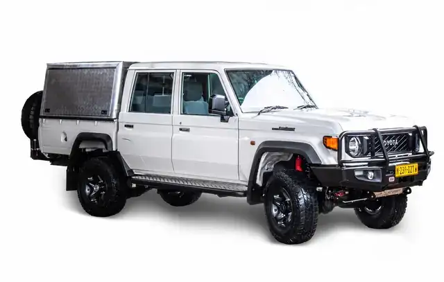Rugged 4x4 vehicle driving on a gravel road in Namibia
